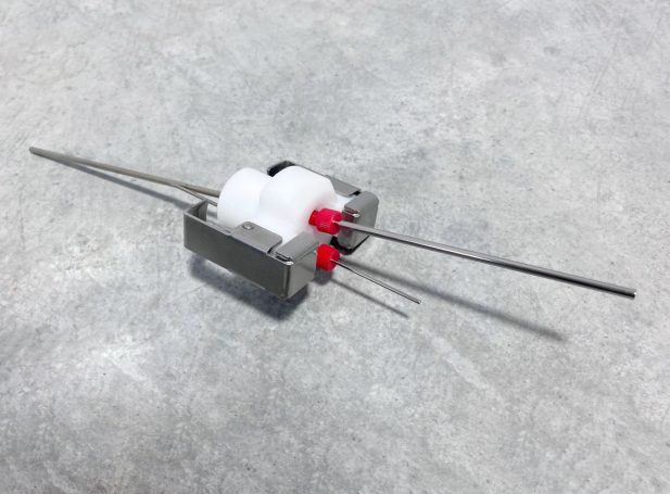 Das Bild zeigt eine aus Plastik- und Metallteilen gebaute Verschlusseinheit für den Medizinbereich.